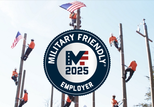 Utility worker trainees on poles with American flags and military friendly award logo.